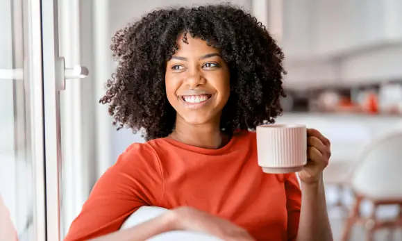 Mujer joven tomando café tranquilamente en referencia a los seguros de vida contra accidentes de seguros Caracas