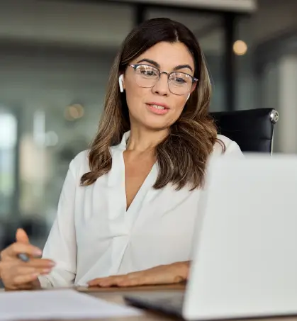 Profesional mujer revisando información en una computadora en referencia a fidelidad, dinero y falsificcación en referencia a los seguros de empresa de Seguros Caracas