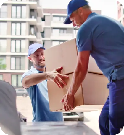 Dos personas de servicio de mudanza están descargando una caja en referencia a coberturas complementarias de seguros hogar de Seguros Caracas